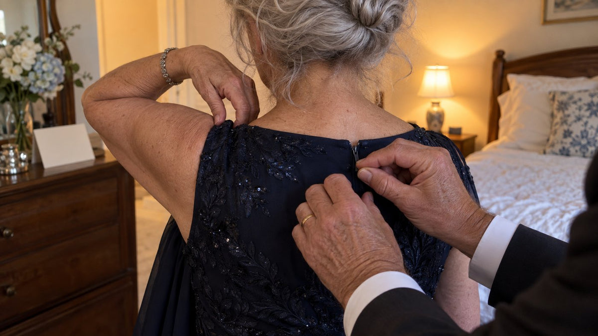 Her husband zipping her dress the morning of the wedding